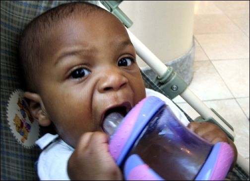 Naji drinks from his sippy cup