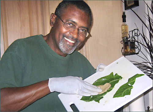 Wayne makes tamales with collard greens wrapping them in his Bridgville DE home.  Heritage Shores is the development.  Photo by E.W. Faircloth